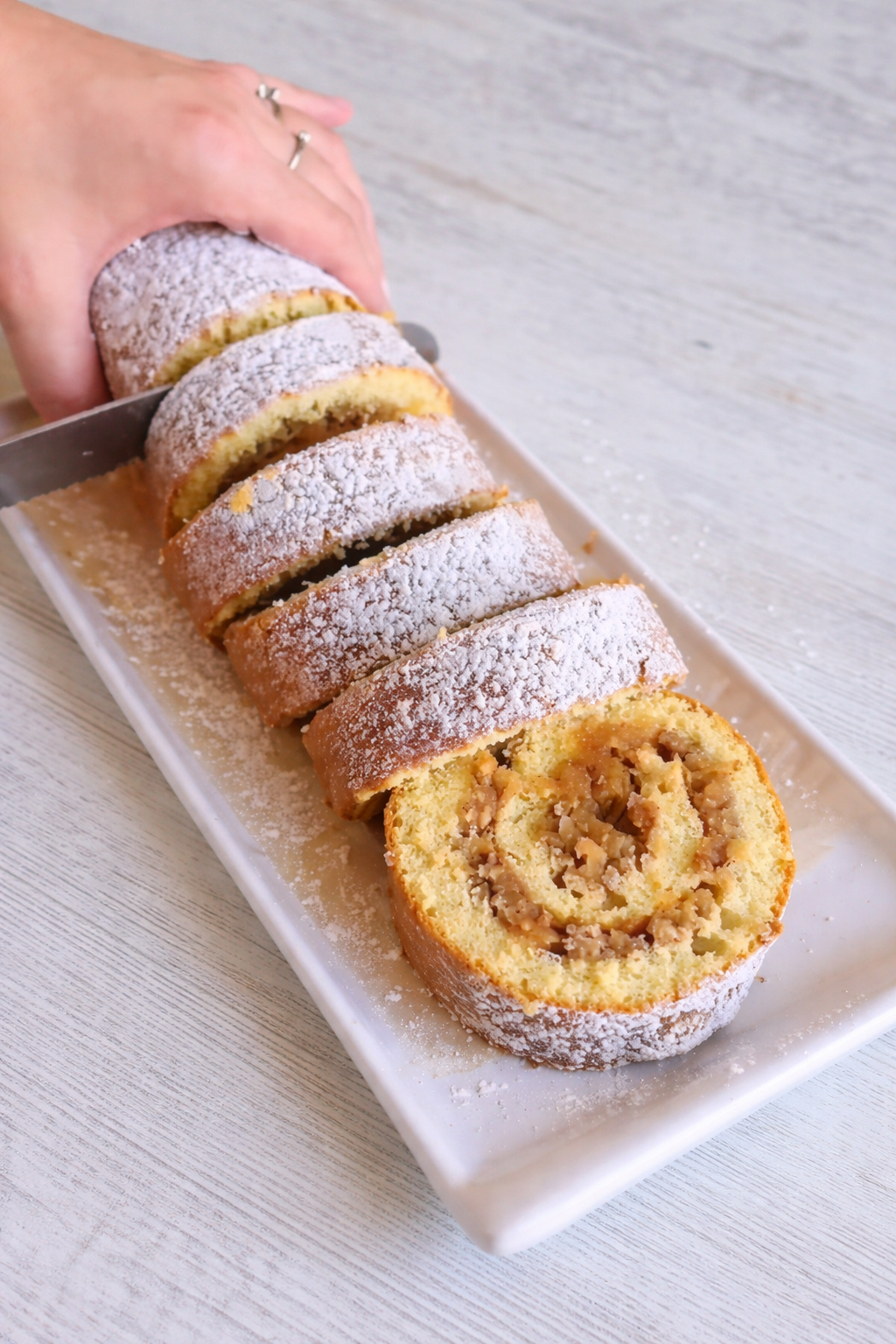 Jednostavni rolat od jabuka sa orasima i cimetom, prikaz presjeka dok se reže na kriške.