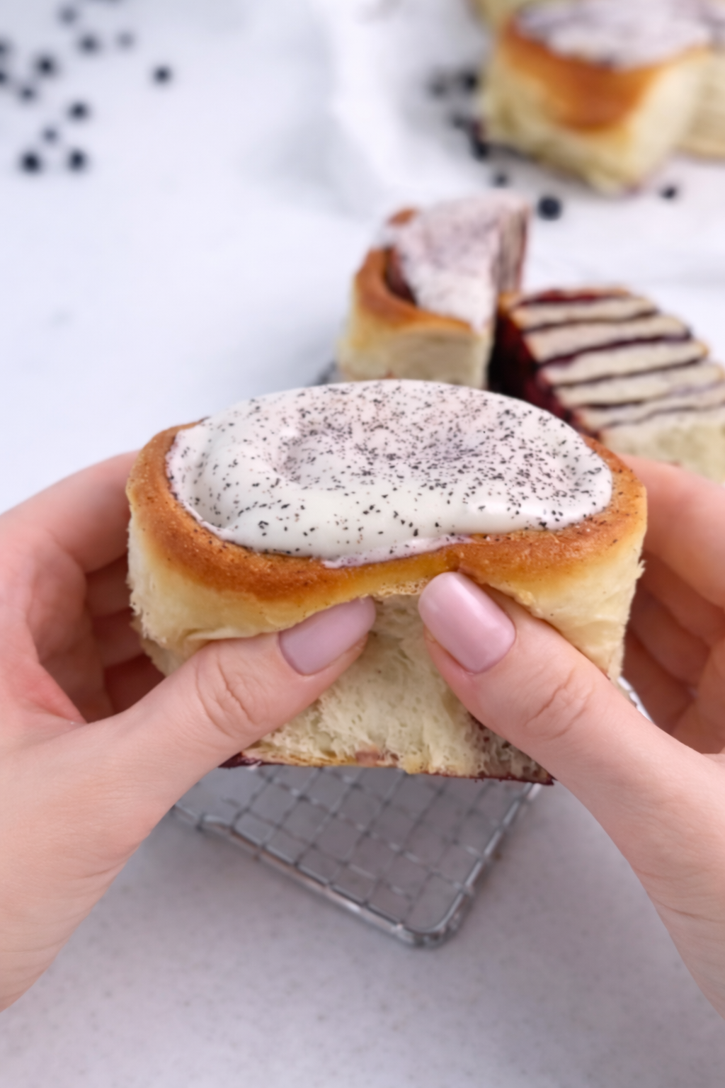 Mekane rolnice s borovnicom prelivene glazurom od krem sira, prikaz pahuljaste unutrašnjosti.