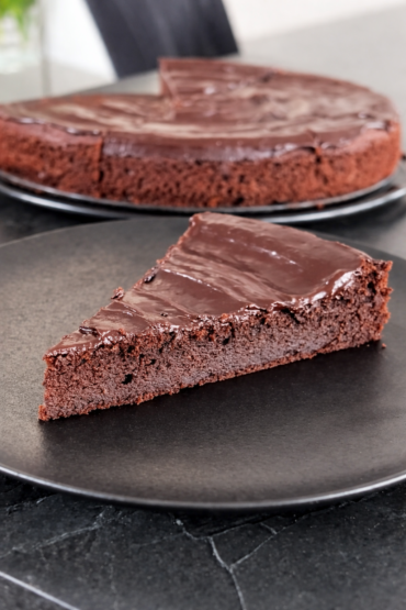 Čokoladni kolač ganache presjek parčeta sa glatkim čokoladnim preljevom i mekanim biskvitom