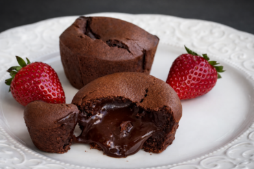 Čokoladni lava cake sa tečnom sredinom serviran uz svježe jagode