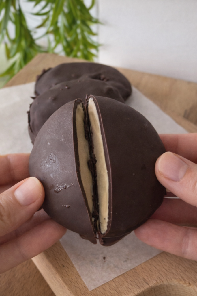 Čokoladni zamrznuti desert od grčkog jogurta i kafe prekriven tamnom čokoladom, prepolovljen da se vidi kremasta unutrašnjost