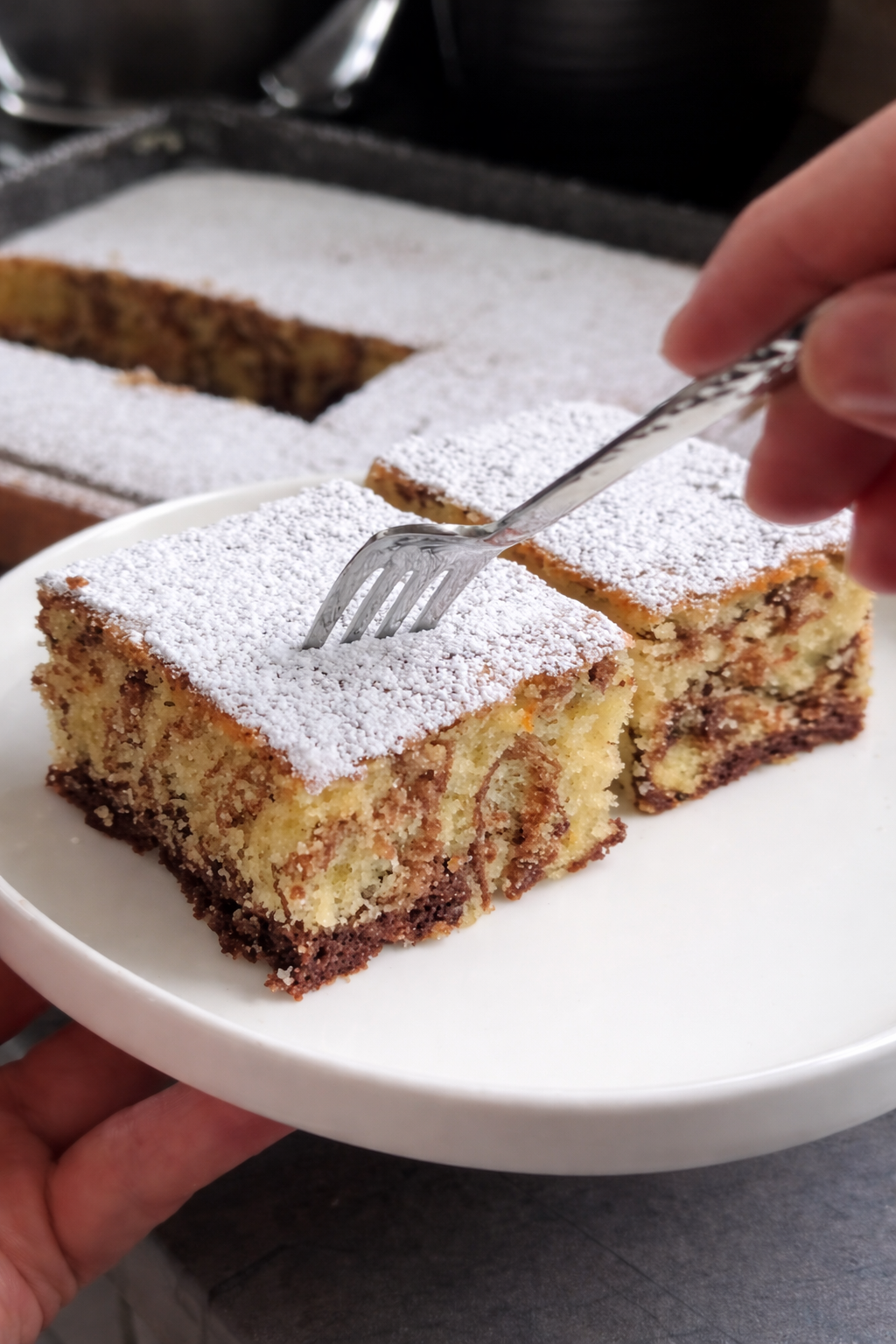 Mramorni kolač sa kakaom, mekan i pahuljast domaći kolač iz pleha posut šećerom u prahu