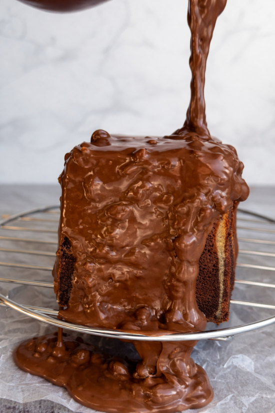 Mramorni kolač preliven bogatom čokoladnom glazurom koja se sliva niz stranice