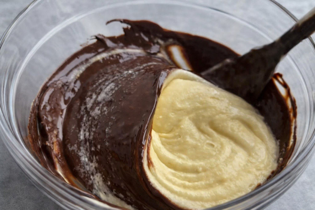 Miješanje čokoladne i vanilija smjese za mramorni kolač u staklenoj zdjeli