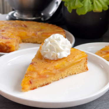 Obrnuti kolač s breskvama, presjek sočnog biskvita s karameliziranim voćem i šlagom