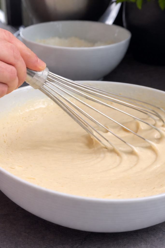 Ručno miješanje smjese za mramorni kolač pjenjačom u velikoj posudi