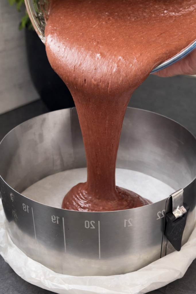 Ulijevanje čokoladne smjese za sočni čokoladni kolač u kalup obložen papirom za pečenje