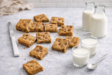 Brzi kolač od putera od kikirikija narezan na štanglice sa komadićima čokolade i čašama mlijeka