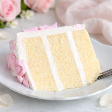 Presjek kolača od vanilije sa glazurom od putera i ružičastom dekoracijom
