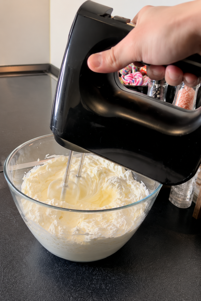 Mascarpone krema sa slatkim vrhnjem muti se mikserom za pripremu torte od vafela sa šumskim voćem bez pečenja.