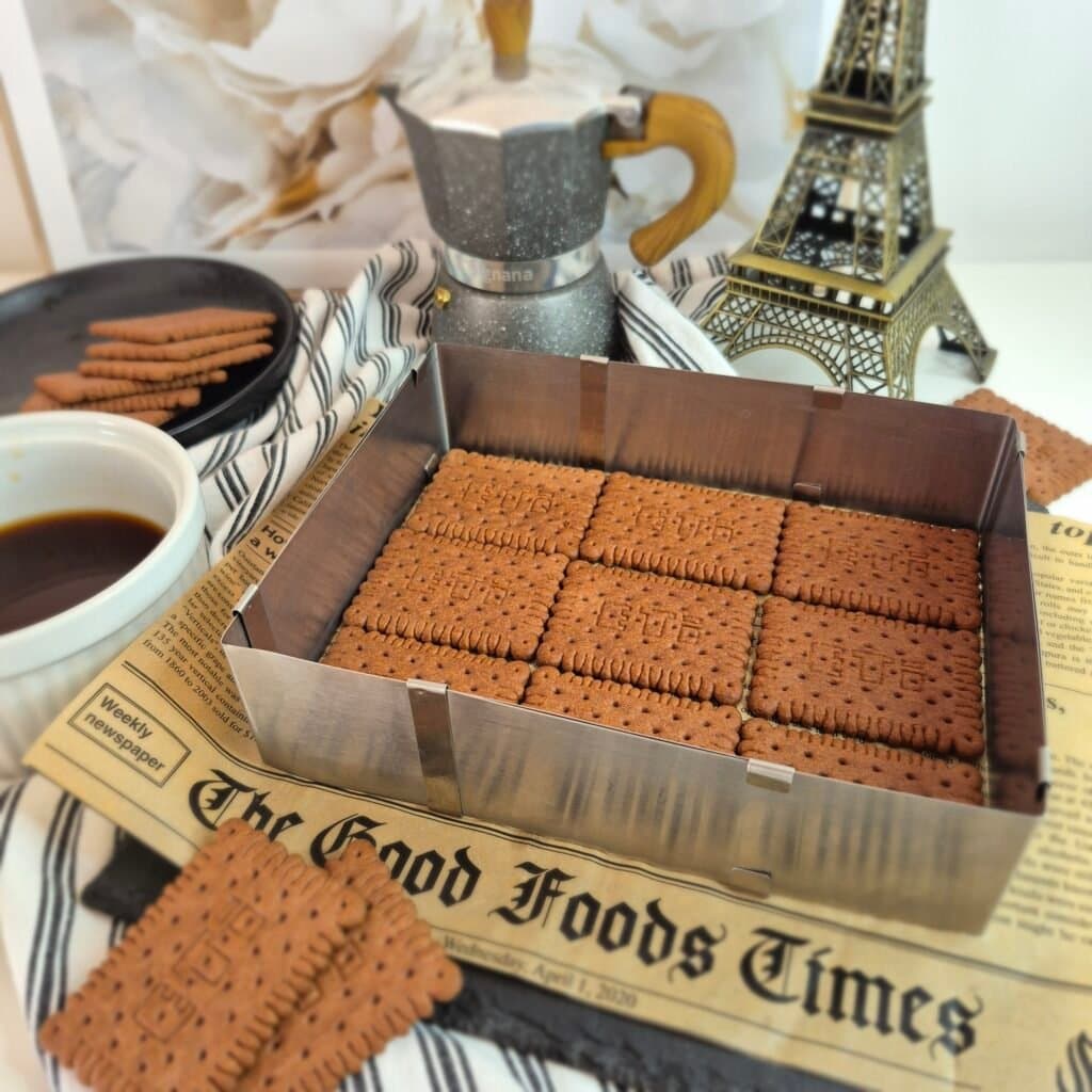 Kakao keksi kratko umočeni u kafu složeni su u prvi sloj torte od kafe i keksa bez pečenja.