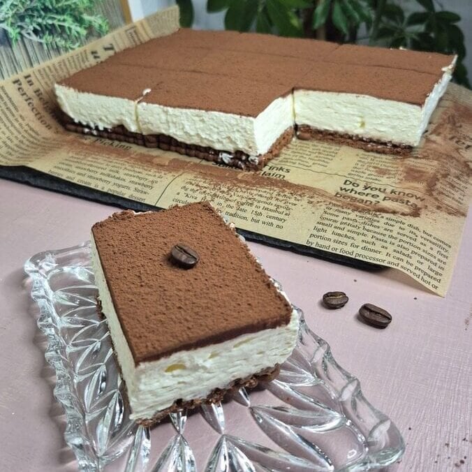 Tiramisu s Nutellom bez pečenja narezan na kocke s mascarpone kremom i kakao prahom.