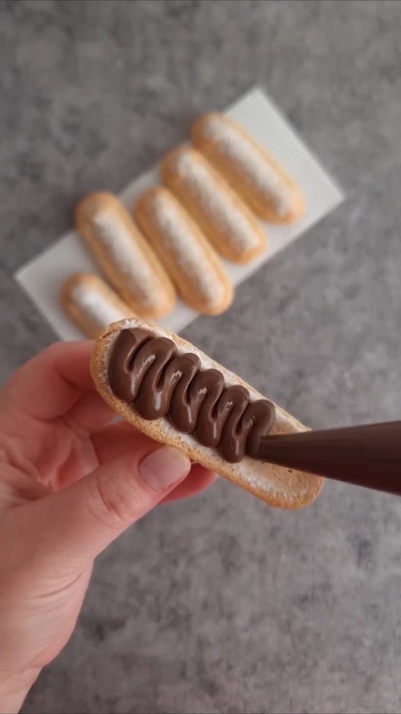 Nutella se istiskuje iz slastičarske vrećice na ravnu stranu piškote