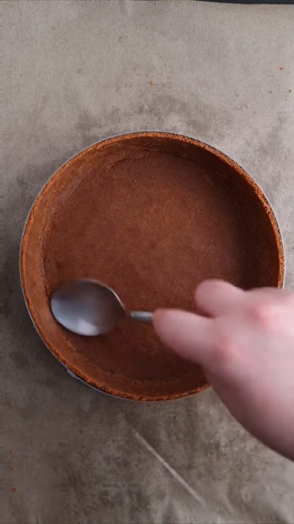 Podloga od keksa za čokoladni tart utiskuje se kašikom po dnu i uz rub okruglog kalupa